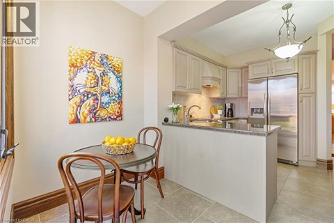 A kitchen with a table and chairs in front of a fridge.
