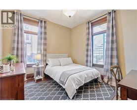 A bedroom with a bed, nightstand, and window with curtains.