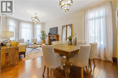 A well-lit dining room with a wooden table and chairs.