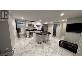 A modern kitchen with a central island and a dining area.