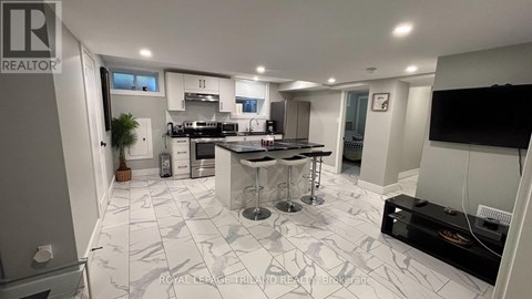 A modern kitchen with a central island and a dining area.