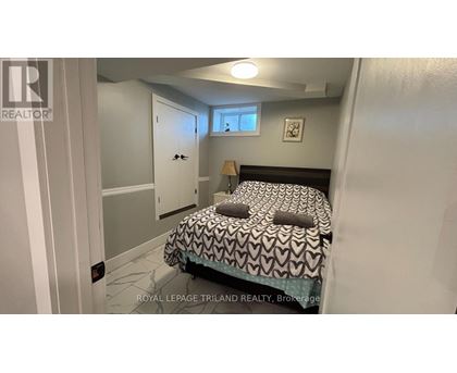 A bedroom with a bed, a window, and a door.