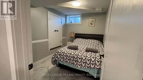 A bedroom with a bed, a window, and a door.