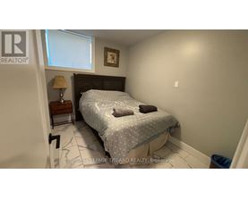 A bedroom with a bed, nightstand, and lamp.