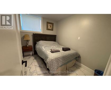 A bedroom with a bed, nightstand, and lamp.
