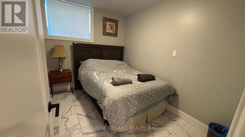 A bedroom with a bed, nightstand, and lamp.