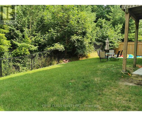 A backyard with a lawn, a fence, and a patio area.