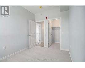 A white bedroom with a carpet floor and a white door.
