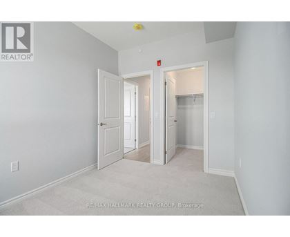 A white bedroom with a carpet floor and a white door.
