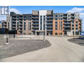 A large apartment complex with a gravel lot in front.