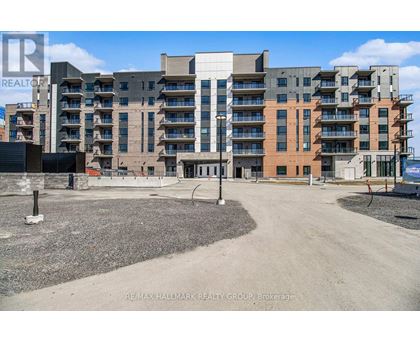 A large apartment complex with a gravel lot in front.