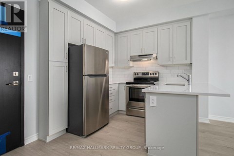 A kitchen with a stainless steel refrigerator and a stove top oven.