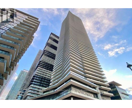 A tall building with a curved facade stands out against a clear sky.