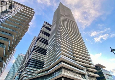 A tall building with a curved facade stands out against a clear sky.