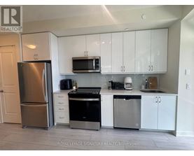 A kitchen with white cabinets and stainless steel appliances.