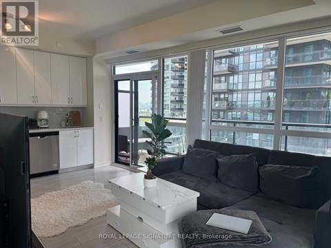 A modern living room with a grey couch and a white coffee table.