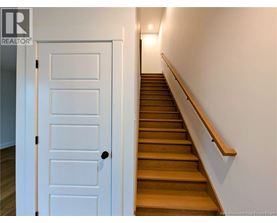 A white door is on the left of a staircase.