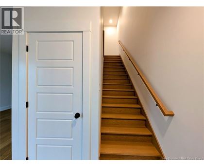 A white door is on the left of a staircase.