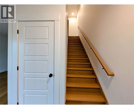 A white door is on the left of a staircase.