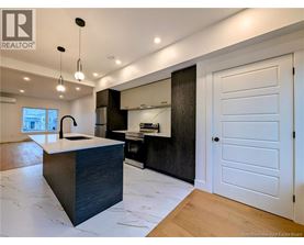 A modern kitchen with a large island and wooden floors.