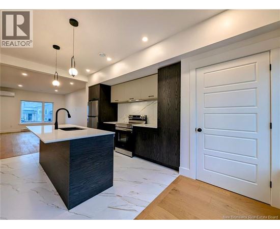 A modern kitchen with a large island and wooden floors.