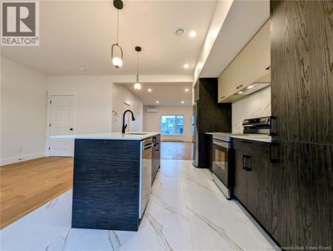 A modern kitchen with dark wood cabinets and a marble floor.