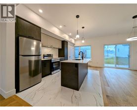 A modern kitchen with a large island and stainless steel appliances.