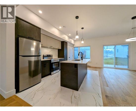 A modern kitchen with a large island and stainless steel appliances.