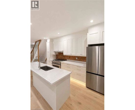 A modern kitchen with white cabinets and a stainless steel refrigerator.