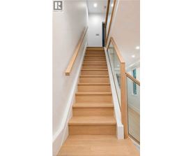 A wooden staircase with glass balustrade.