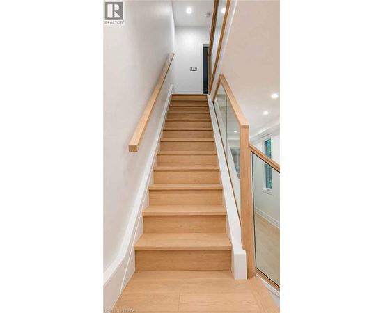 A wooden staircase with glass balustrade.