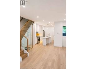 A modern kitchen with a wooden floor and white walls.