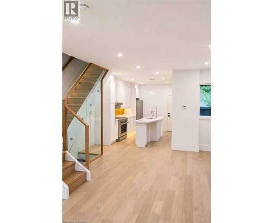 A modern kitchen with a wooden floor and white walls.