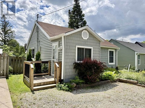 A small house with a porch and a garden in front.