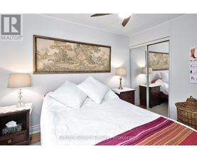 A bedroom with a large bed and a painting on the wall.