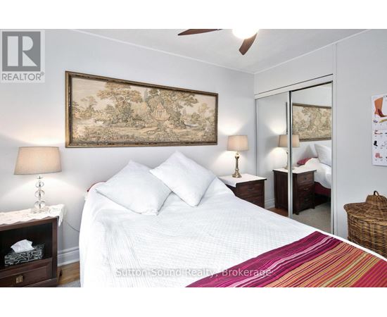 A bedroom with a large bed and a painting on the wall.