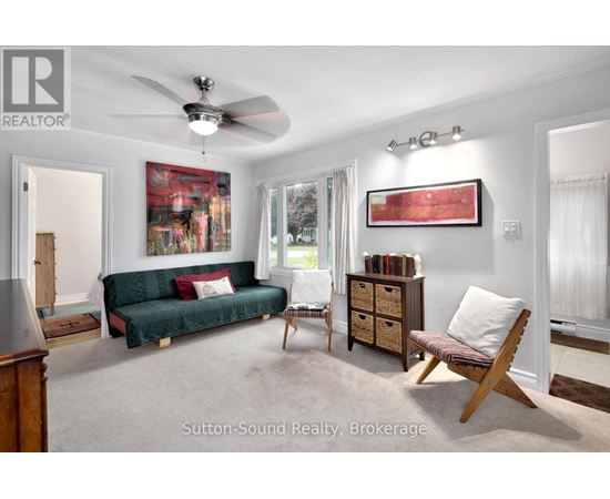 A living room with a green couch and a wooden chair.
