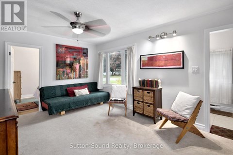 A living room with a green couch and a wooden chair.