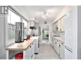 A kitchen with white cabinets and a wooden island.