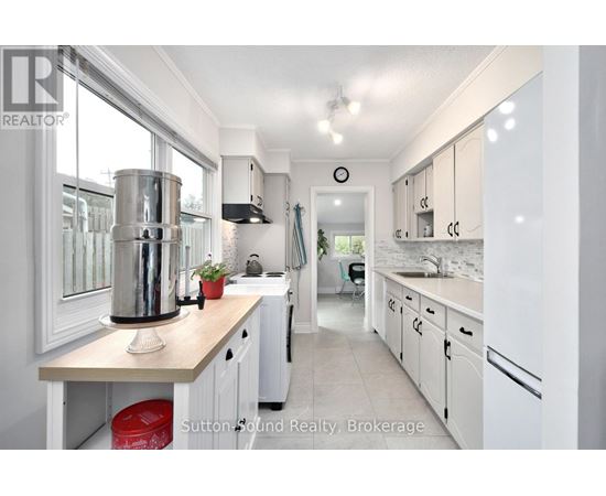 A kitchen with white cabinets and a wooden island.