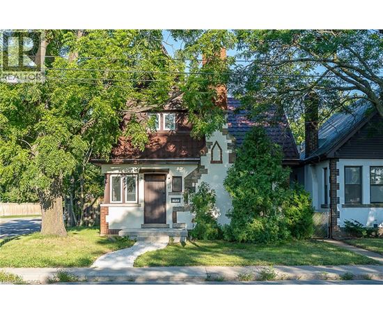 A house with a brown door is surrounded by greenery.