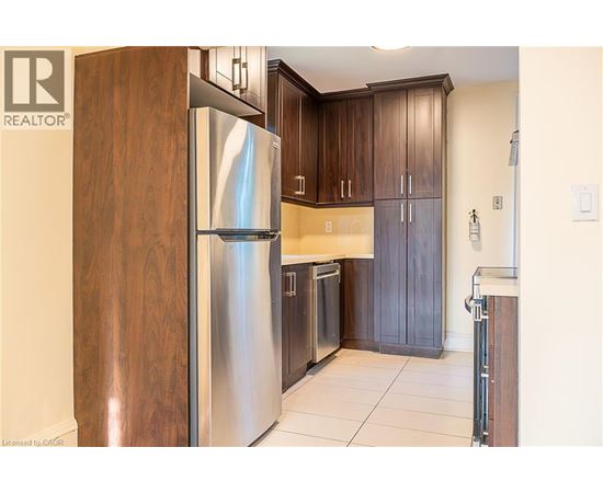 A modern kitchen with a stainless steel refrigerator and wooden cabinets.