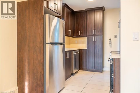A modern kitchen with a stainless steel refrigerator and wooden cabinets.