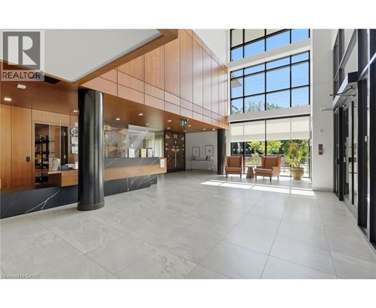 A spacious lobby with a reception desk and a large window.