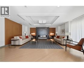 A living room with a white couch, a black coffee table, and a wooden floor.