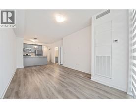 A spacious, empty room with light wood flooring and white walls.
