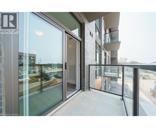 A balcony with glass doors leading to a building with the logo TR REALTOR.