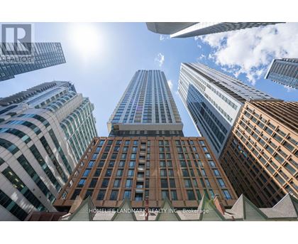 A view of a cityscape with tall buildings and a clear blue sky.