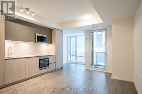 A spacious kitchen with wooden cabinets and a microwave built into the cabinetry.