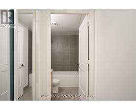 A white bathroom with a toilet and a shower stall.